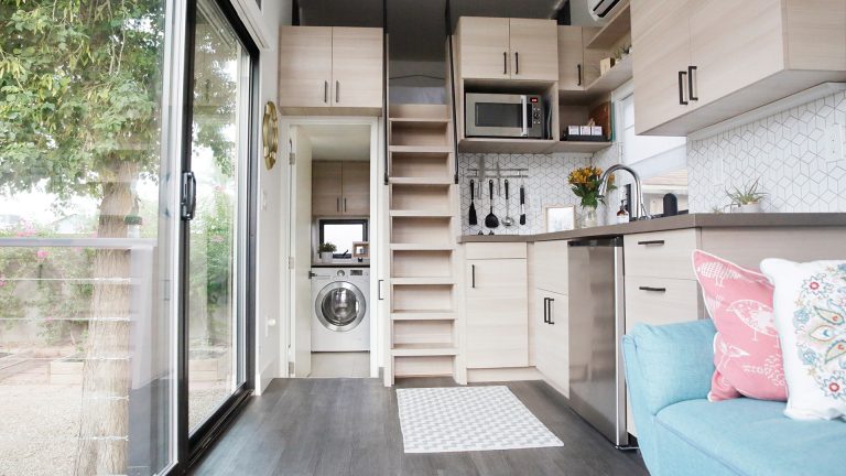 Blick in den Wohn-/Schlaf/Küchen-Bereich eines Tiny Houses mit einer versteckten Waschküche.