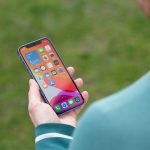 Eine Person h&auml;lt ein iPhone 12 in der Hand und blickt darauf.