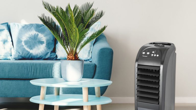 Ein Raum mit einem Sofa und einem kleinen Sofatisch. Daneben steht der Bestron Summer Breeze.