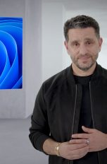 Panos Panay Panos Panay, Chief Product Officer bei Microsoft, steht vor der Kamera. Im Hintergrund ist das Logo von Windows 11 zu sehen.