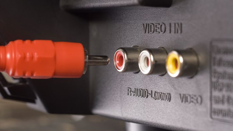 Auf der Rückseite eines TV-Gerätes befindet sich ein Composite-Anschluss mit drei Cinch-Buchsen, ein Cinchstecker befindet sich vor der roten Buchse.