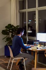 Eine Person sitzt am Abend an einem Rechner und arbeitet.