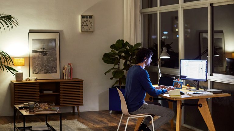 Eine Person sitzt am Abend an einem Rechner und arbeitet.