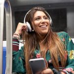 Eine Person fährt in der Bahn und hört dabei Musik von ihrem Smartphone.