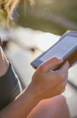 E-Book-Reader Eine Person sitzt im Freien und hält einen E-Book-Reader in der Hand.