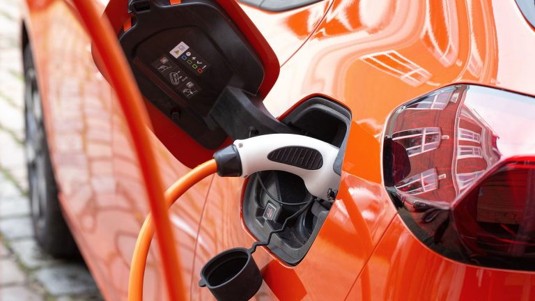 Ein Typ-2-Stecker steckt in einem orangen Opel Corsa-e.