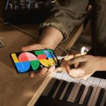 Eine Person h&auml;lt das Google Pixel 5a in der Hand, das per USB-C aufgeladen wird.