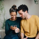Zwei Personen schauen zusammen auf ein Smartphone.