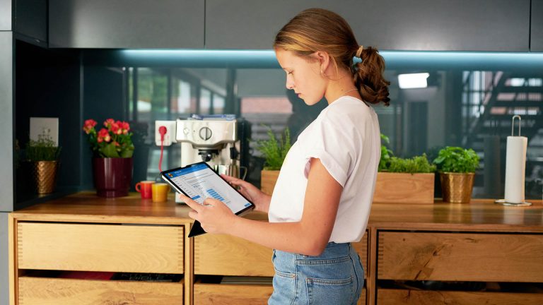 Eine Person hält ein Tablet in der Hand. Darauf sind die Einstellungen einer Fritzbox zu sehen.