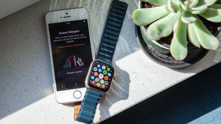 Ein iPhone SE und eine Apple Watch SE liegen nebeneinander.