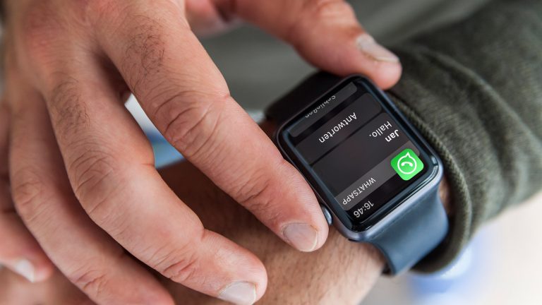 Eine Person trägt eine Apple Watch am Handgelenk. In der Nahaufnahme ist eine eingehende WhatsApp-Nachricht auf dem Display zu erkennen.