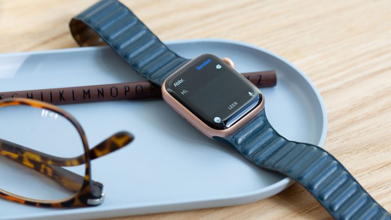 Eine Apple Watch liegt neben einer Brille in einer Schale. Auf dem Display der Uhr ist eine noch leere Nachricht geöffnet.