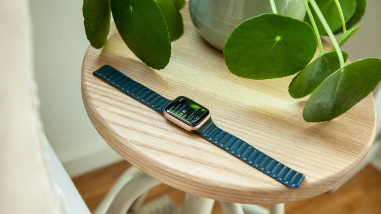 Eine Apple Watch liegt auf einem Nachttisch.