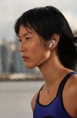 Apple AirPods 3. Generation Eine Person ist mit den neuen AirPods der dritten Generation im Regen unterwegs.