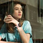 Eine Person sitzt in einem Café und schaut aus dem Fenster. An ihrem Handgelenk ist eine Huawei Watch GT 3 zu sehen.