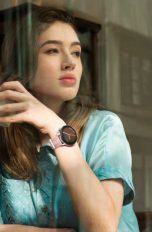 Eine Person sitzt in einem Café und schaut aus dem Fenster. An ihrem Handgelenk ist eine Huawei Watch GT 3 zu sehen.