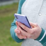 Eine Person h&auml;lt ein iPhone in der Hand.