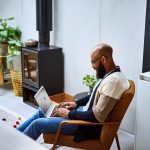 Eine Person hat einen Laptop auf dem Scho&szlig;.