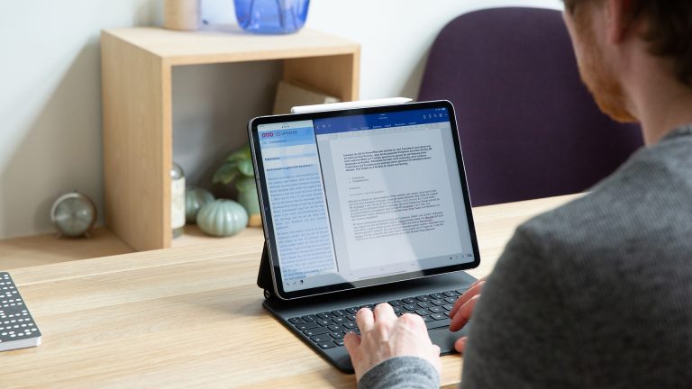 Eine Person sitzt vor einem iPad Pro und nutzt den Stage Manager.