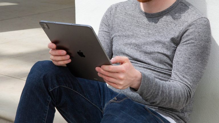 Eine Person hält ein iPad Pro im Freien in der Hand.