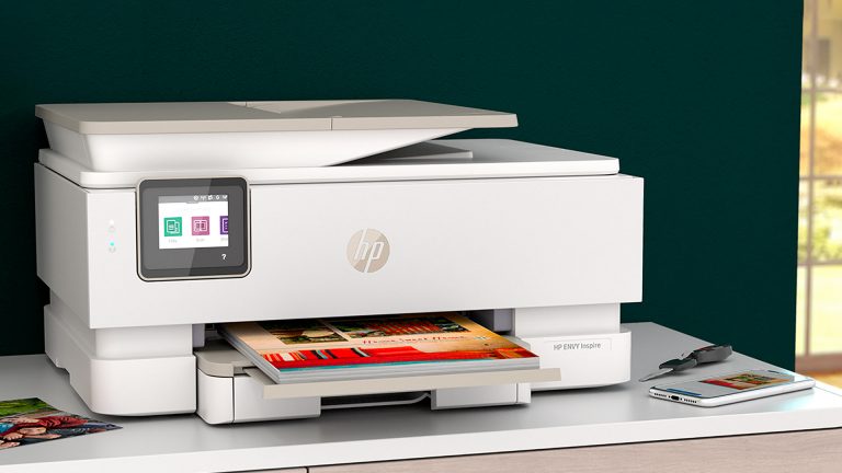 Ein HP-Drucker steht auf einer Kommode. Daneben liegt ein Smartphone, das die Druckvorschau eines Ausdrucks zeigt.
