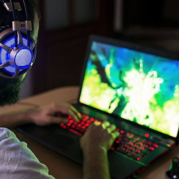 Eine Person spielt etwas an einem Gaming-Notebook.