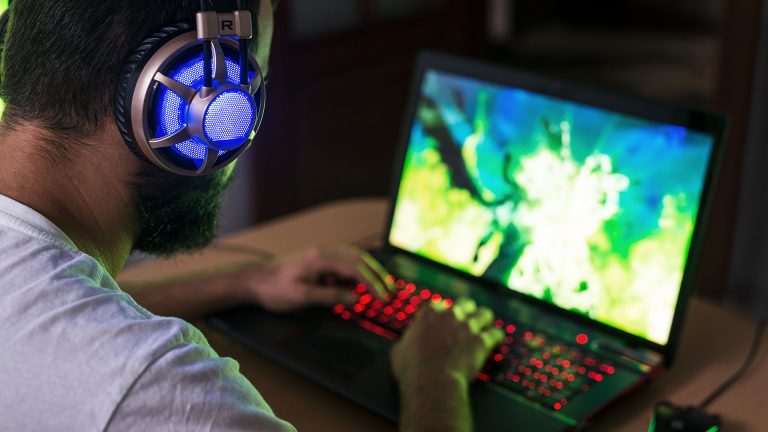 Eine Person spielt etwas an einem Gaming-Notebook.