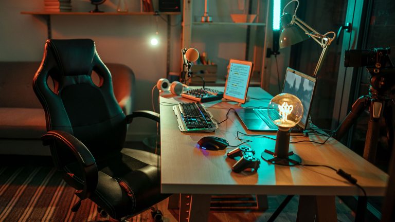 Blick auf einen Schreibtisch mit einem Laptop und Gaming-Peripherie.
