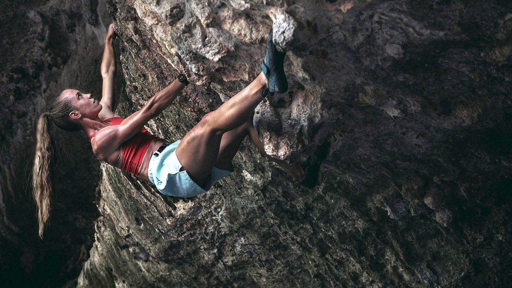 Eine Person klettert einen Berg hinauf. Sie trägt eine Smartwatch von Garmin.