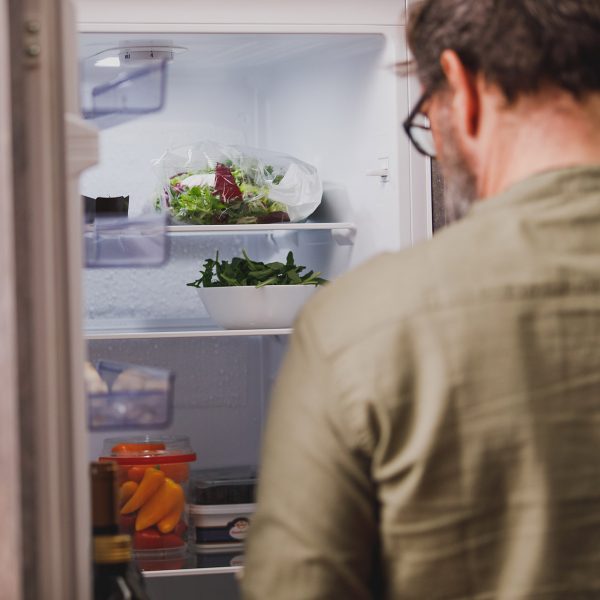 Eine Person blickt in einen K&uuml;hlschrank.
