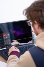 Eine Person sitzt vor einem Ultrabook mit Windows-Betriebssystem.