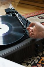 Plattenspieler-Nadel Eine Person legt vorsichtig die Nadel eines Plattenspielers auf eine Platte auf.