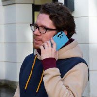 Eine Person hält sich ein Samsung Galaxy A52S ans Ohr, um zu telefonieren.