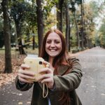 Eine Person nimmt ein Selfie mit einer Sofortbildkamera auf.