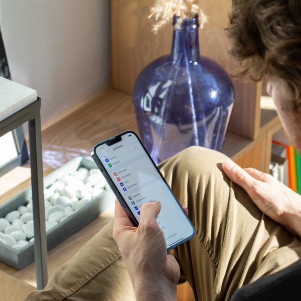 Eine Person liegt auf dem Sofa und bedient gerade ein iPhone.