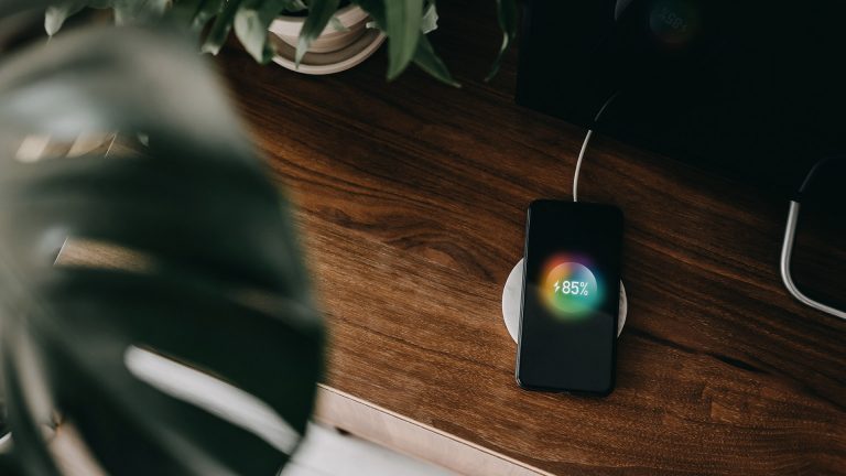 Ein Smartphone liegt auf einer induktiven Ladestation und lädt.