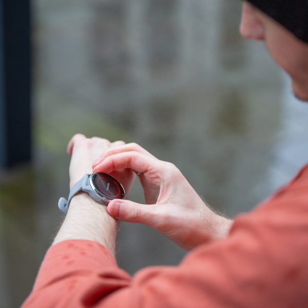 Eine Person blickt auf ihre Smartwatch.