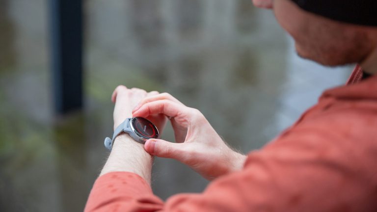 Eine Person blickt auf ihre Smartwatch.