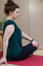 Eine Person macht eine Übung auf einer Yoga-Matte, am linken Handgelenk trägt sie eine Smartwatch.