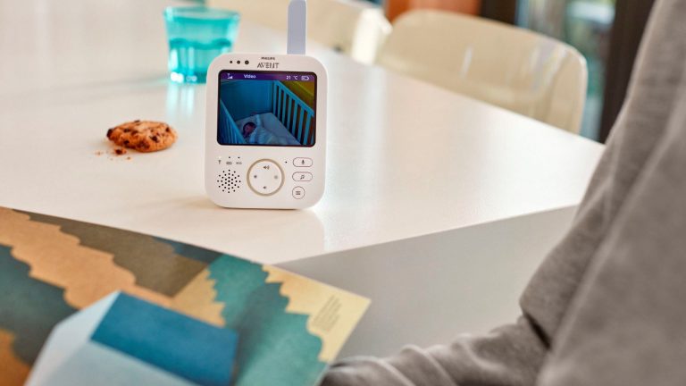Das Elternteil von einem Philips-Avent-Babyphone mit eingeschaltetem Video seht auf einem Tisch.