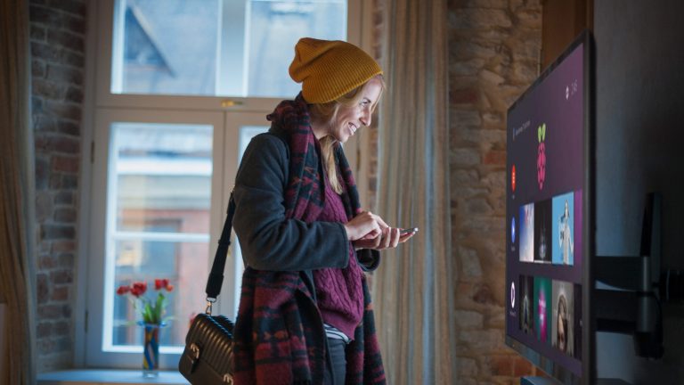 Eine Person steht sehr nah an einem Fernseher, auf dem ein Raspberry Pi als Multimedia-Device Mediatheken anzeigt.