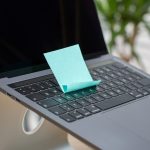 Auf der Tastatur eines MacBooks klebt ein t&uuml;rkisfarbener Post-it.