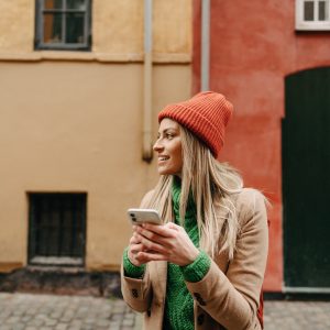 Eine Person steht mit ihrem Smartphone auf der Straße.