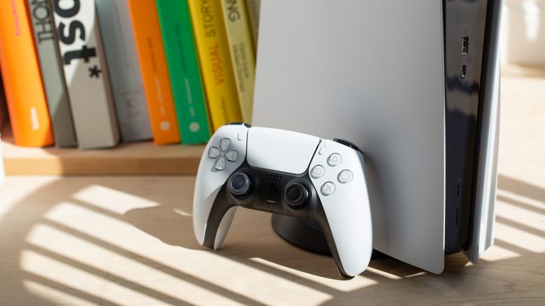 Ein PS5 Dualsense-Contoller lehnt an einer PS5.
