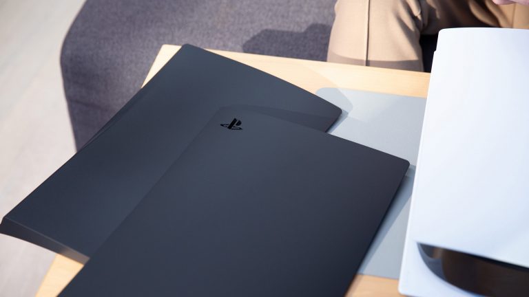 Zwei Seitenteile in Schwarz liegen neben einer PlayStation 5.