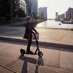 Eine Person fährt mit einem E-Scooter durch die Hamburger Hafen City.