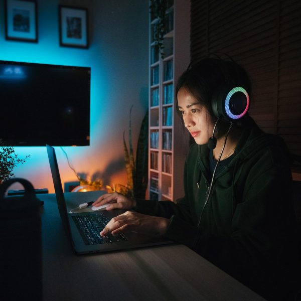 Eine Person sitzt an einem Gaming-Notebook.