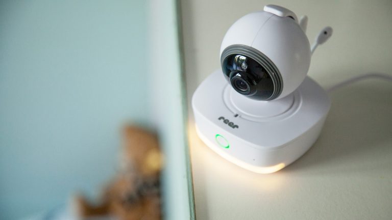 Eine Reer IP Babycam Move steht mit eingeschaltetem Nachtlicht auf einer Anrichte.