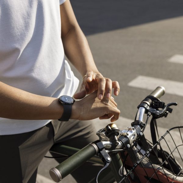 Eine Person sitzt auf einem Fahrrad und trägt eine Google Pixel Watch am rechten Handgelenk.