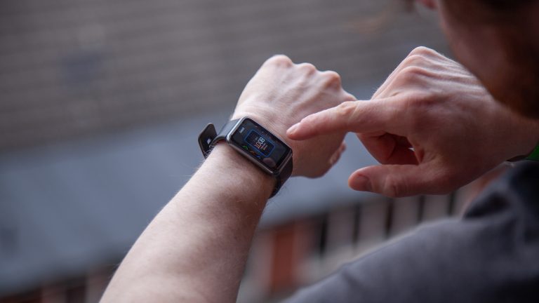 Eine Person tippt auf das Display einer Huawei Watch Fit.